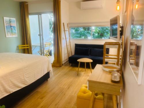 1 dormitorio con cama, sofá y mesa en Studio Fresh&Cosy Trois-Ilets - 3 étoiles-Hotel Carayou, en Les Trois-Îlets
