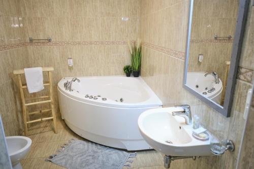 Hotel Pernigele في Jelgavkrasti: حمام مع حوض أبيض ومغسلة
