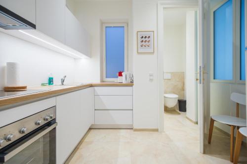 Brand Cozy Apartment في فيينا: مطبخ أبيض مع حوض ومرحاض