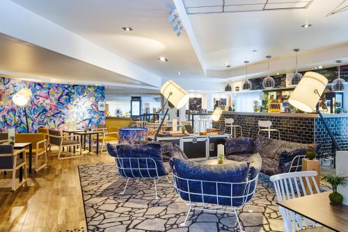 a restaurant with blue chairs and tables at Novotel Paris Rueil Malmaison in Rueil-Malmaison