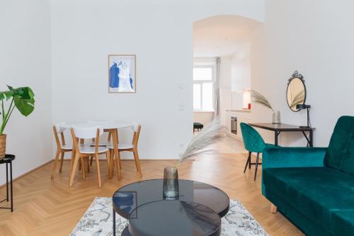 Brand Cozy Apartment في فيينا: غرفة معيشة مع أريكة خضراء وطاولة