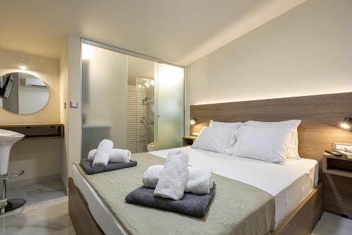 1 dormitorio con 1 cama grande y toallas. en Chris and Stratos villa with private ecologic pool and kid's playground!, en Mourniaí