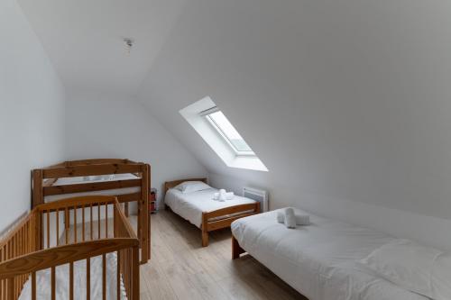 sypialnia z 2 łóżkami i świetlikiem w obiekcie TY PRAT - Jolie maison neuve proche mer w mieście Landunvez