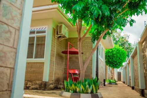 a red chair sitting outside of a house at Randa Cottages Moshi in Kirua