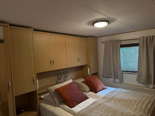 um quarto com uma cama e armários e uma janela em Chalet Makkum V10 em Makkum