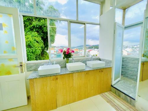 a bathroom with two sinks and a large window at Dalat Backpacker's Alley Hostel in Da Lat