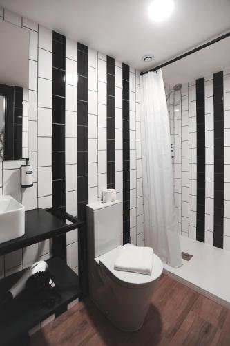 a black and white bathroom with a toilet and a shower at Alma Candida 02 in Valença