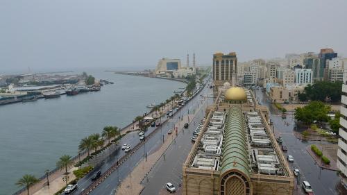 Al Jazeerah Hotel في الشارقة: اطلاله على مدينه بها نهر ومبنى