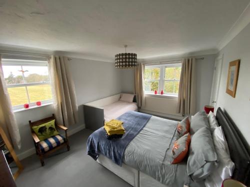 a bedroom with a bed and a couch and two windows at Beautiful country house in Inkpen in Inkpen