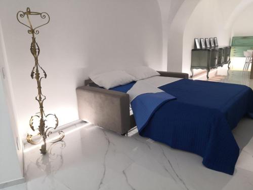 a bedroom with a bed with a blue blanket on it at LianHome b&b "Volte" in Lucera