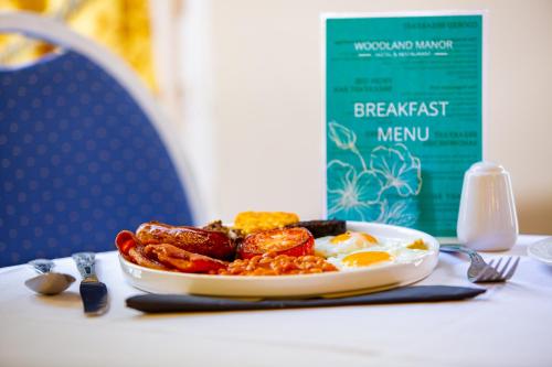 a plate of food on a table with eggs and beans at Woodland Manor Hotel in Bedford