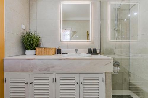 W łazience znajduje się umywalka i przeszklony prysznic. w obiekcie COTOVIA VILLA luxury and golf vacations w mieście Quinta do Lago
