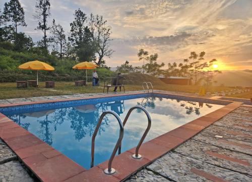 a swimming pool with a sunset in the background at LaHermitage Resort in Lansdowne