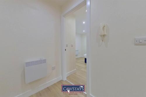 un pasillo con una habitación con una pared blanca en Beauchamp House - Apartment in Coventry City Centre, Sleeps 4, Free secure parking, by CovStays en Coventry