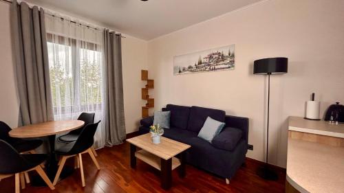 een woonkamer met een blauwe bank en een tafel bij Mala Italia Apartments in Wrocław