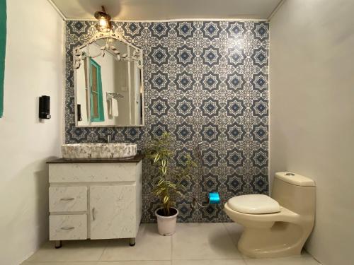 a bathroom with a toilet and a sink and a mirror at Casa Happy Dervish, 2mins away from the beach in Anjuna