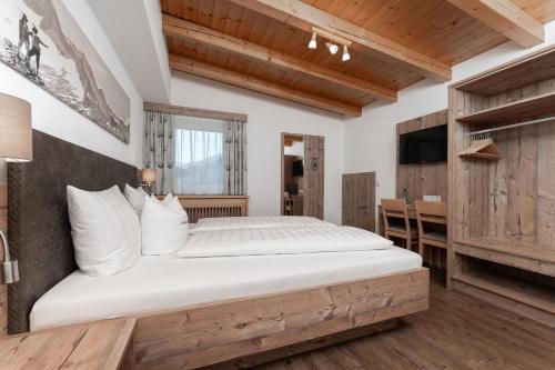 a bedroom with a large bed and a desk at Haus Margret in Sankt Leonhard im Pitztal