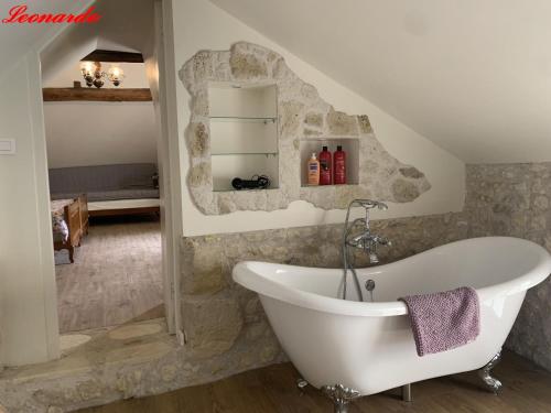 een badkamer met een wit bad in een kamer bij Clos Lussault - 4 gîtes, separate or together in Lussault-sur-Loire
