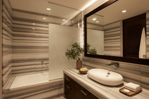 a bathroom with a sink and a shower and a mirror at Mare Ayia Napa in Ayia Napa