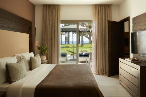 a hotel room with a bed and a sliding glass door at Mare Ayia Napa in Ayia Napa