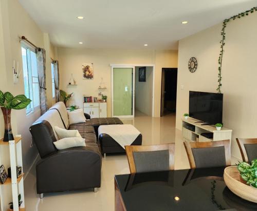 a living room with a couch and a tv at Villa for rent in Ko Chang