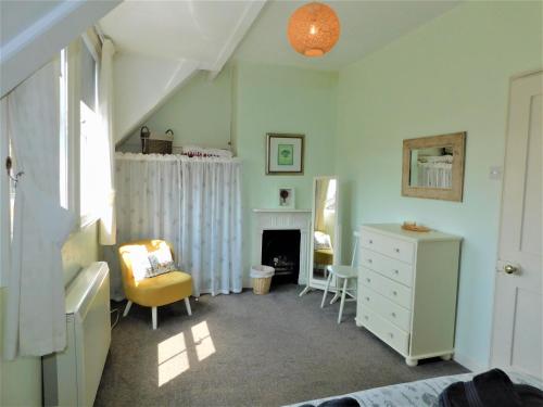 sypialnia z białą komodą i kominkiem w obiekcie 1 Orchard Cottages w mieście West Runton