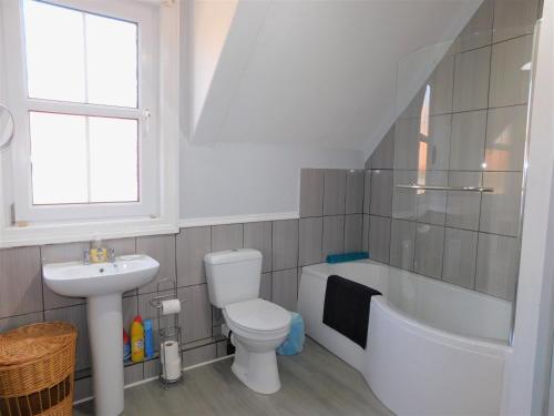 W łazience znajduje się umywalka, toaleta i wanna. w obiekcie 1 Orchard Cottages w mieście West Runton