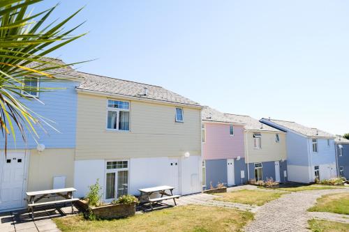 a row of houses with benches in front of them at Atlantic Reach Resort in Newquay