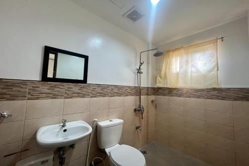 a bathroom with a toilet and a sink at Dinah's Tourist Inn Puerto Princesa in Puerto Princesa City