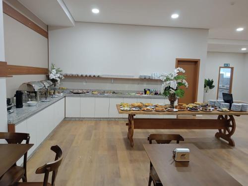 uma cozinha com uma mesa com pratos de comida em HOTEL MAESTRO EXECUTIVE PATO BRANCO em Pato Branco