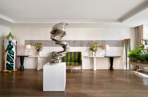 a living room with a statue in the middle of a room at Haymarket Hotel, Firmdale Hotels in London