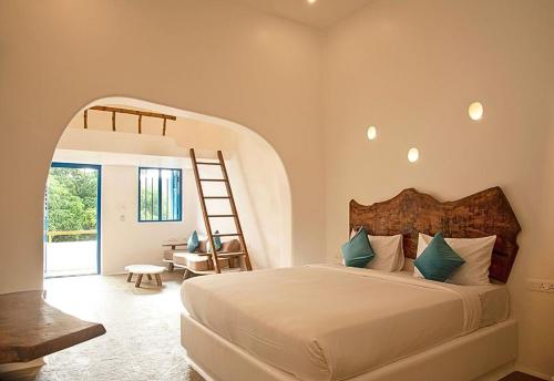 a bedroom with a bed and a ladder in a room at Conch Resort Luxury Private Pool Suites in Puducherry