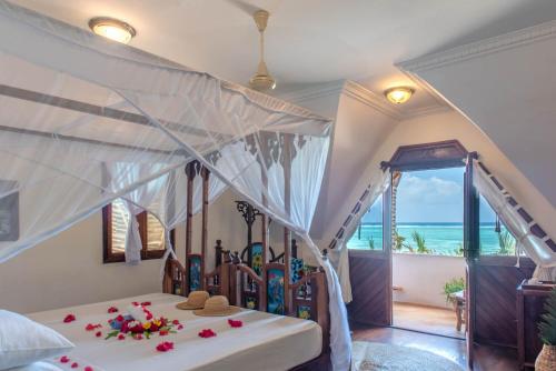 a bedroom with a bed with a view of the ocean at Zoi Retreat Hotel Zanzibar in Matemwe