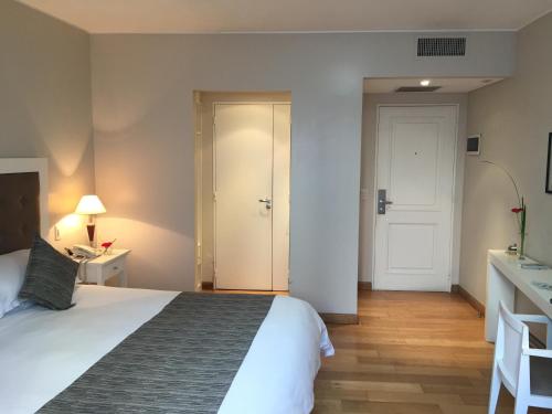 a hotel room with a large bed and a door at Purobaires Hotel Boutique in Buenos Aires