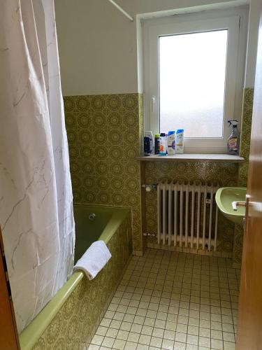 a bathroom with a green tub and a sink at Gästehaus Rachinger in Pappenheim
