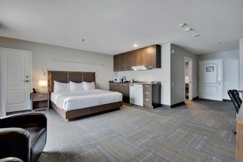 a hotel room with a bed and a kitchen at Hôtel et Pavillons Le Petit Manoir du Casino in La Malbaie