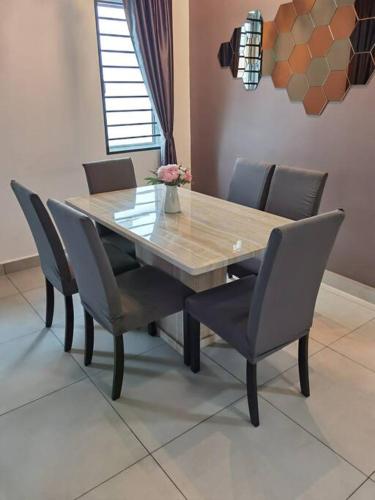 a dining room table and chairs with a wooden table at Cosy 2-Storey Holiday Home Vines 2 @Pasar Malam -1 in Brinchang