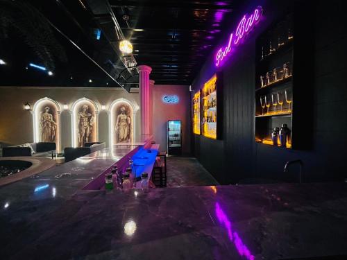 a bar in a restaurant with purple lights at Je t'aime cafe & villa in Sing Buri