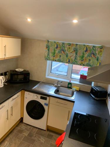 a small kitchen with a sink and a washing machine at Pasture Place in Goole