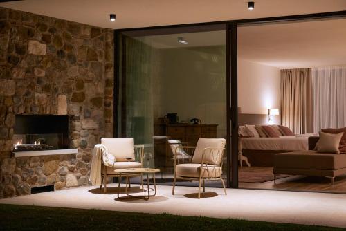 a living room with two chairs and a bedroom at Relais Rossar Boutique Hotel Garda & Hills in Costermano