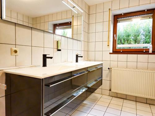 a bathroom with a sink and a mirror at Relax & Business Apartment 122qm mit Balkon, Kamin und Disney+ in Sindelfingen