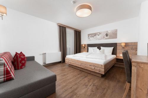 a hotel room with a bed and a couch at Haus Margret in Sankt Leonhard im Pitztal