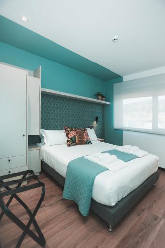 a bedroom with a bed and a blue wall at Alma Candida 11 in Valença