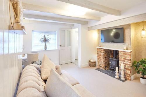 a living room with a couch and a fireplace at Bridge Cottage in Yarm in Yarm
