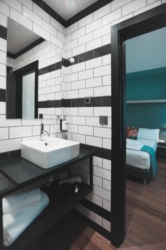 a bathroom with a sink and a mirror and a bed at Alma Candida 11 in Valença