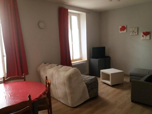 een woonkamer met een bank, een stoel en een televisie bij Appart résidence Le Dordogne in La Bourboule