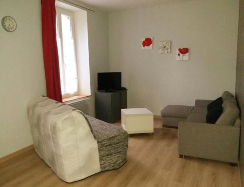 een woonkamer met een bank en een stoel bij Appart résidence Le Dordogne in La Bourboule
