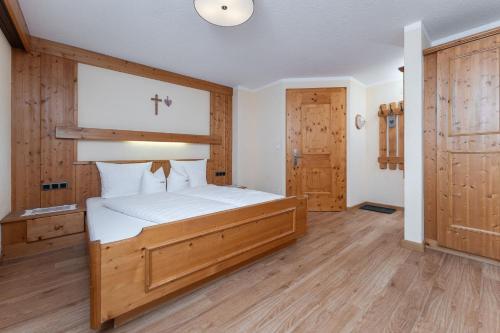 a bedroom with a bed with a cross on the wall at Haus Margret in Sankt Leonhard im Pitztal