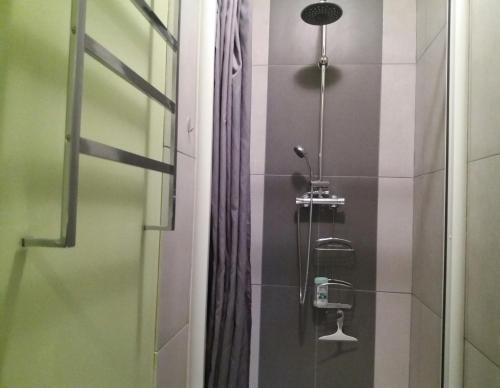 een douche in een badkamer met een glazen deur bij Appart résidence Le Dordogne in La Bourboule