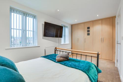 1 dormitorio con 1 cama y TV de pantalla plana en Elegant Bolton Abode - Sleeps 10, en Bolton